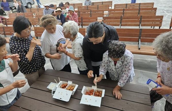 제주시 한림읍 비양도 주민들이 드론이 배송한 치킨을 먹고있다. 사진=제주도 제공