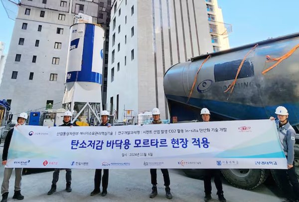 롯데건설이 지난 6일 한일시멘트와 함께 개발한 ‘CO₂(이산화탄소) 주입 바닥용 모르타르’ 기술을 현장에 적용하고 기념촬영을 하고 있다. 사진=롯데건설